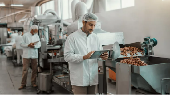 Man standing with a tablet in a manufacturing plant